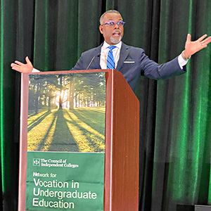 Eddie Glaude Jr. standing at podium with arms outstretched