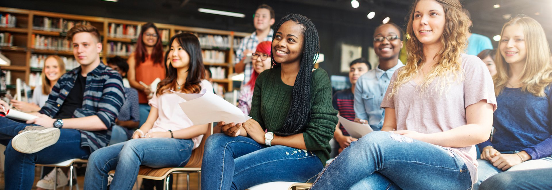Students sitting and standing in a library