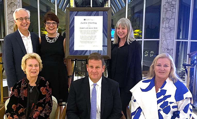 Hales and others pose near framed award