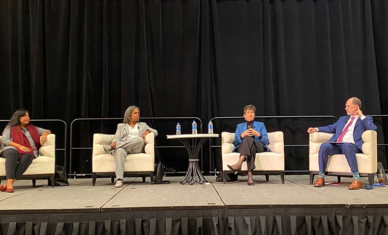 Four speakers seated on stage