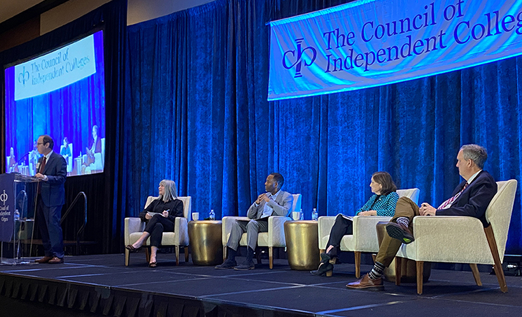 Four speakers seated on stage