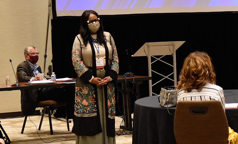 Speaker standing before seated participants