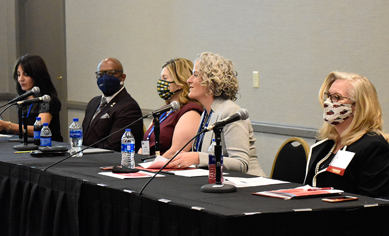 Five presenters seated at table