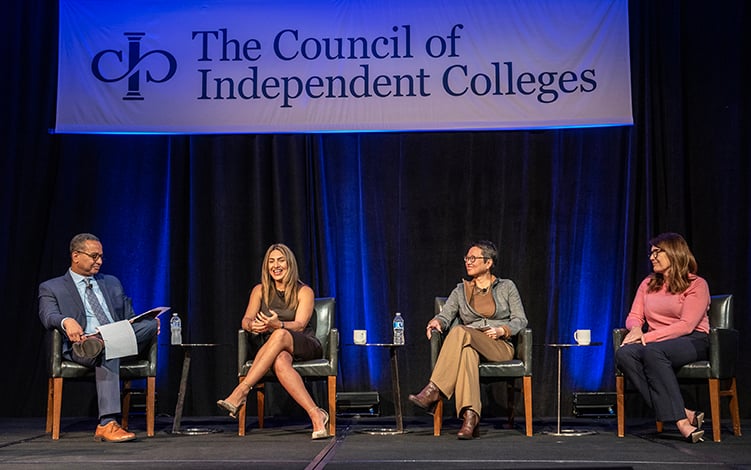 Four panelists seated on stage