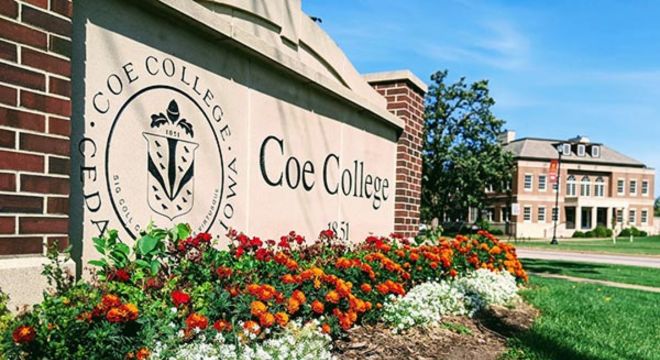 A photo of the Coe College brick entrance sign. Planted flowers are located in front of the sign.