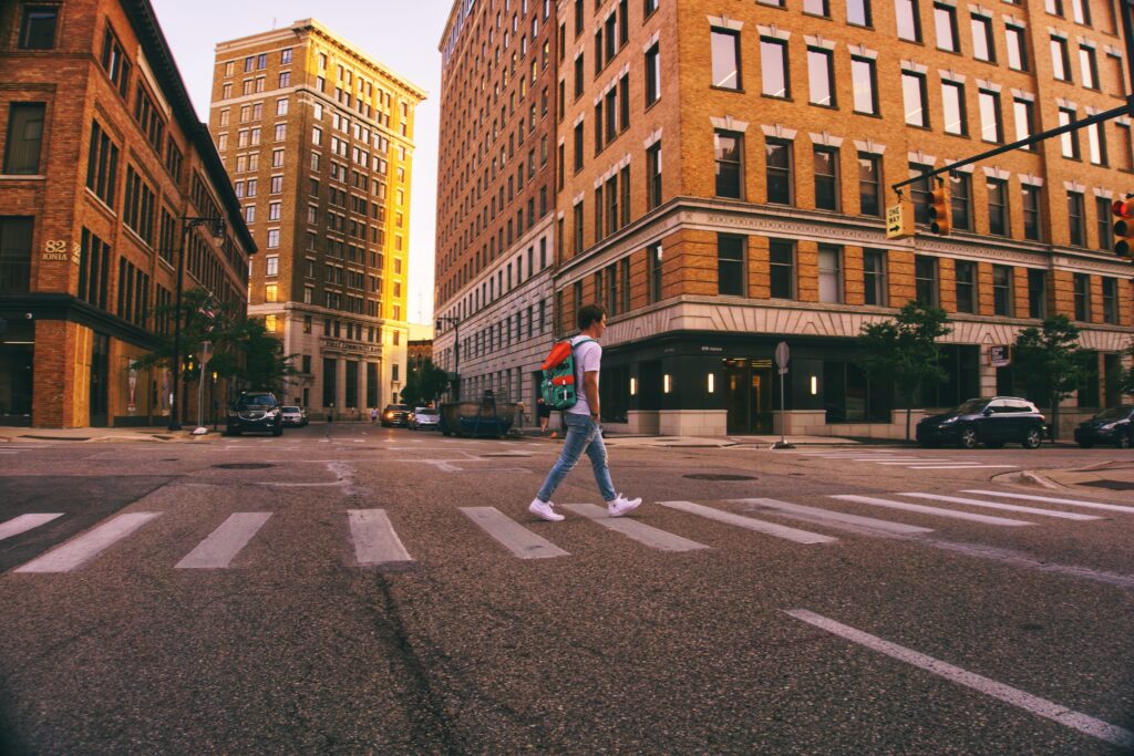 Street view of a pedestrian crossing a crosswalk in downtown Grand Rapids, MI.