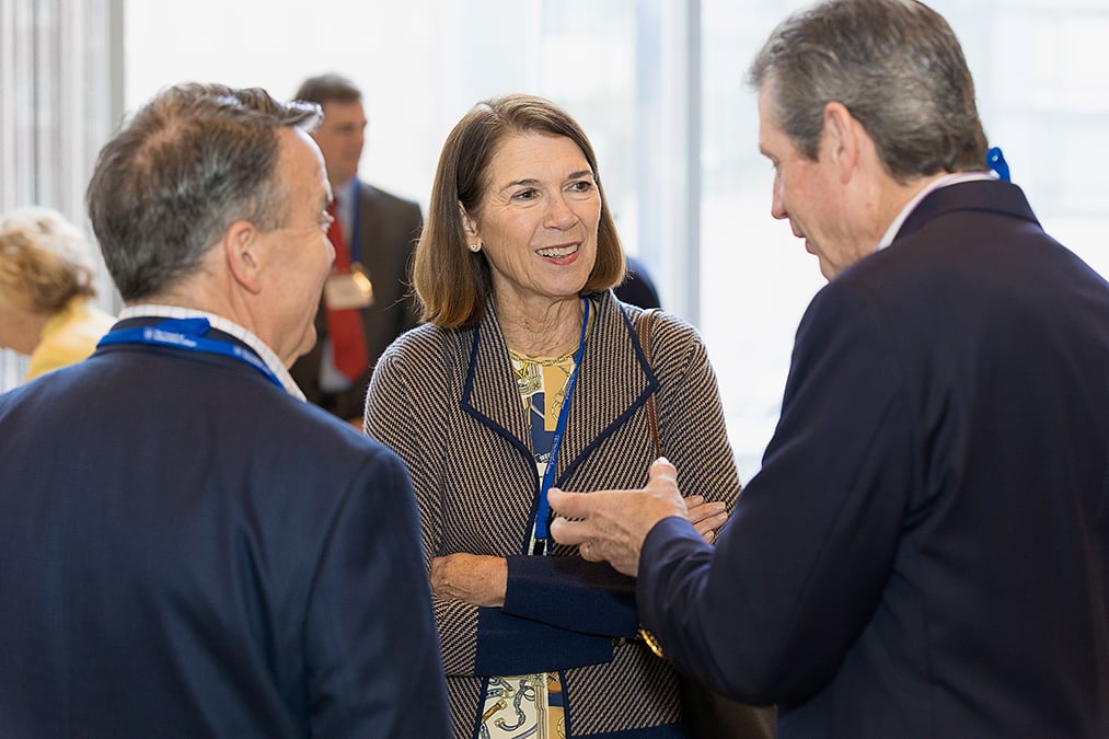Three participants stand and talk after a session