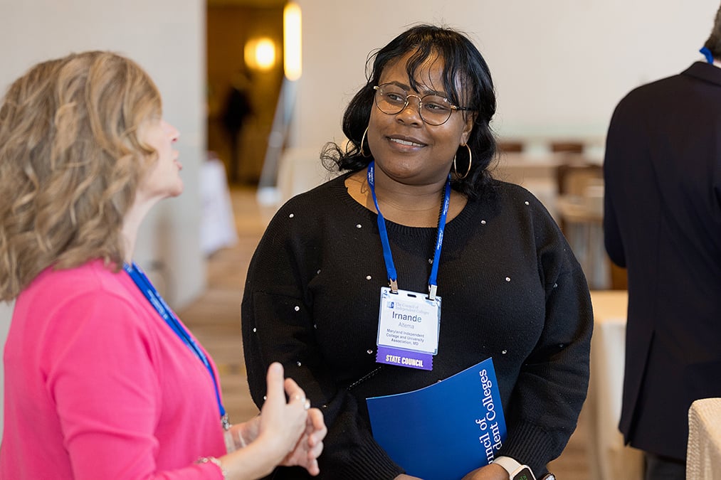 Two participants stand and talk between sessions