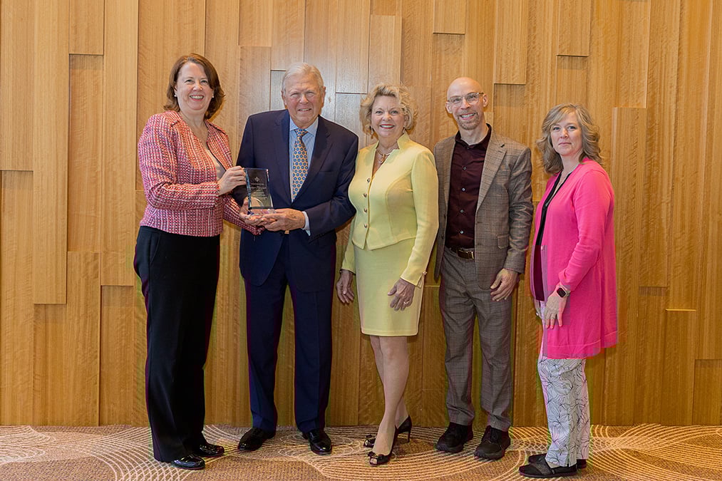 CIC staff and award recipients stand posing for photo holding award