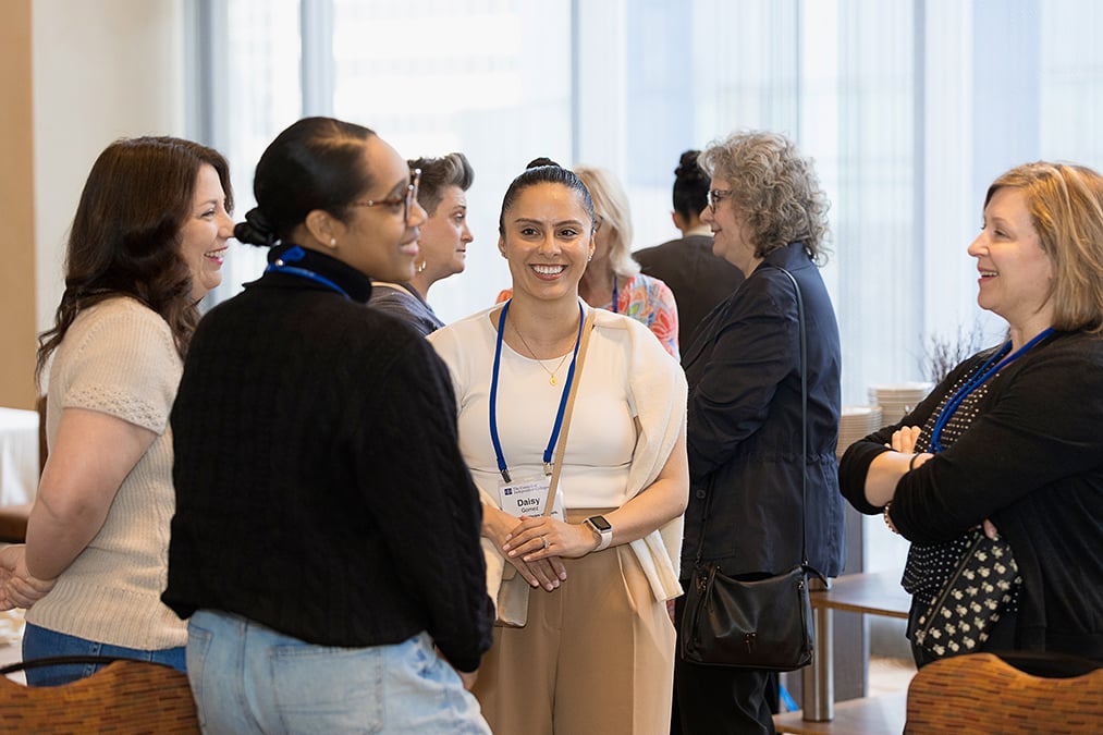 Participants stand and talk between sessions