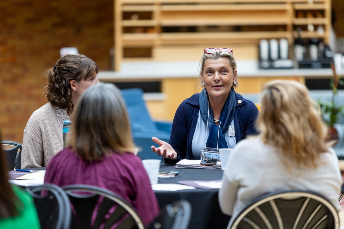 A table of participants in mid-discussion during the 2024 NetVUE regional gathering hosted by Calvin University and Aquinas College.