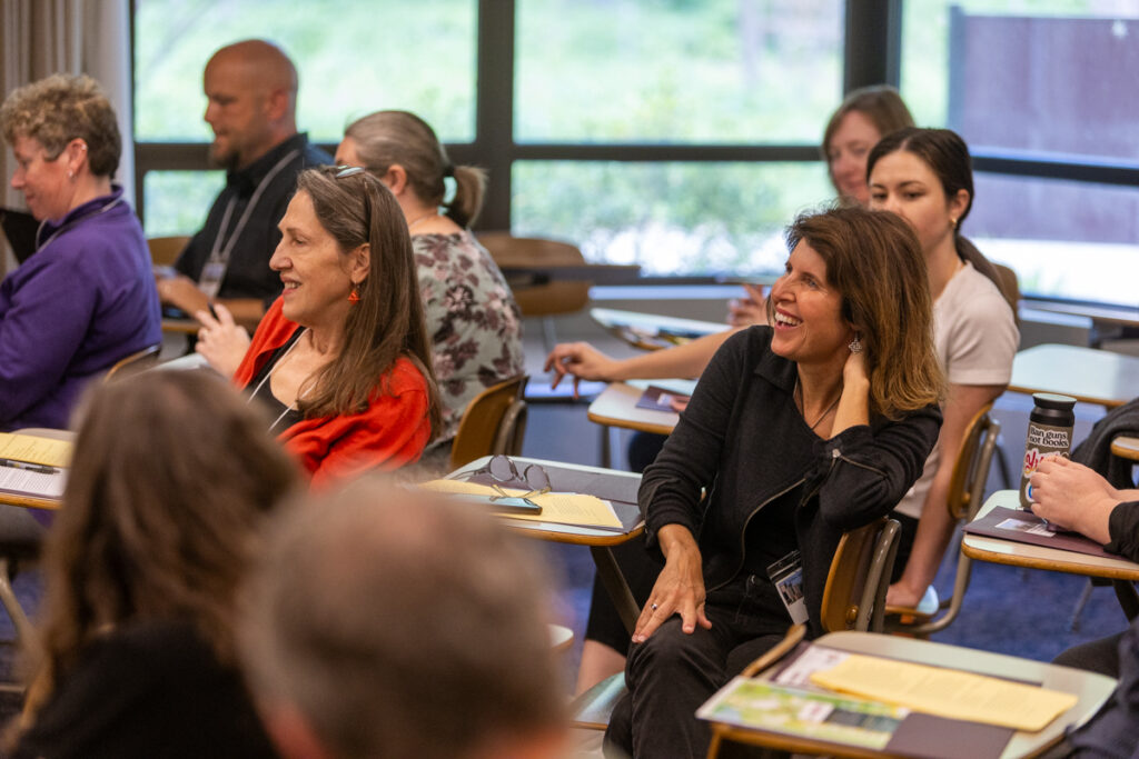 Participants are seated in a classroom and listen to a speaker during a breakout session at the 2024 NetVUE regional gathering hosted by Calvin University and Aquinas College.