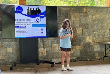 Student presents while looking at notes on her phone