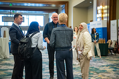 Participants and sponsor representatives talking in exhibit hall