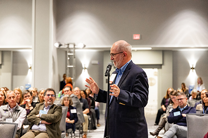 Participant stands at microphone to ask a question during a plenary session