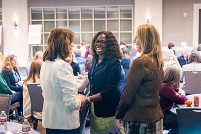 Titi Ufomata speaking with two participants in a session room