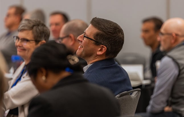 Participants seated at roundtables during a session
