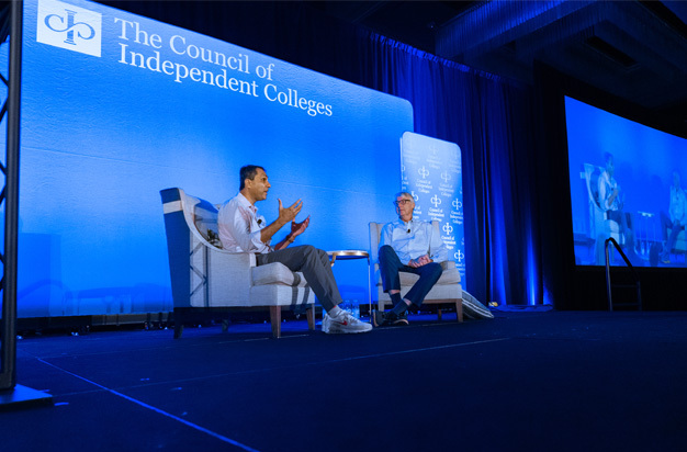 Eboo Patel and Grant Cornwell speak during plenary session while seated in chairs on stage