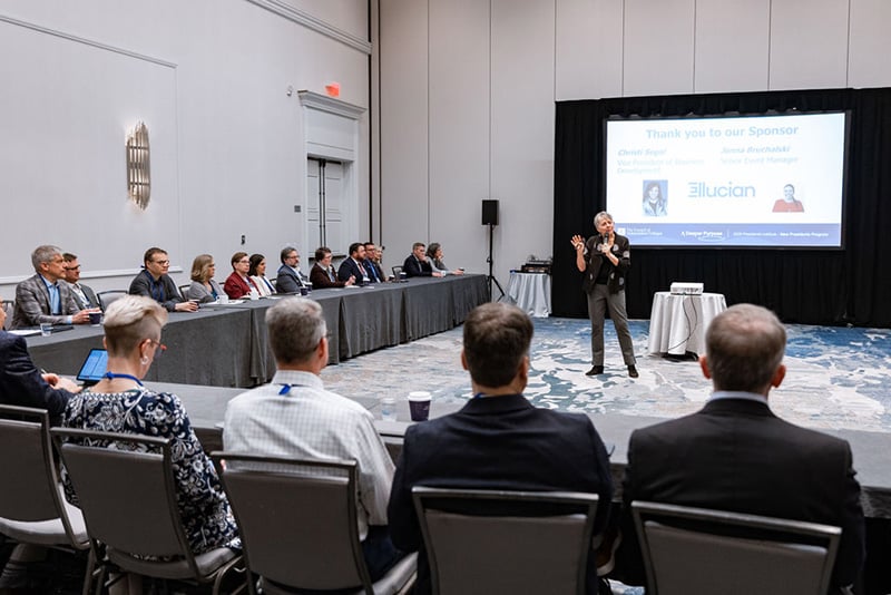 Speaker stands in middle of hollow square of seated participants