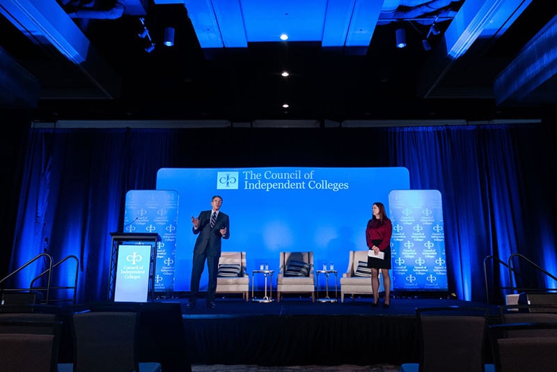 Two lawyers present on a legal issues while standing on stage