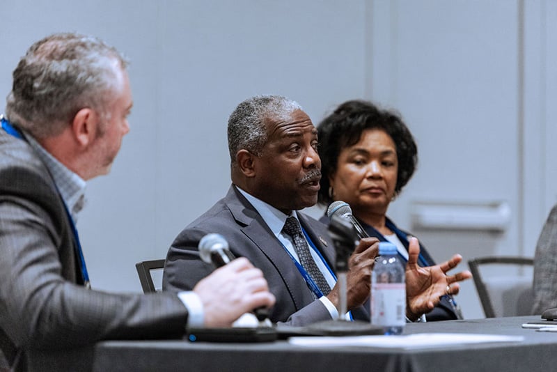 Three speakers seated at head table