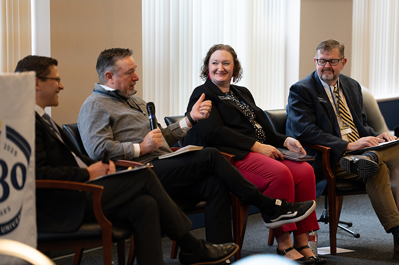 Four administrators from Bushnell University present while seated in chairs
