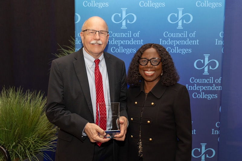 Jeff Frick holds award and poses with Titi Ufomata