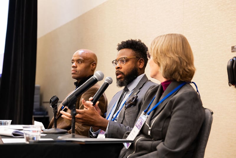 3 speakers presenting while seated at head table
