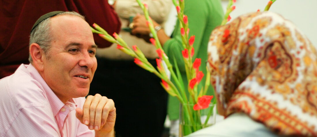 A man speaking with a woman wearing a headscarf