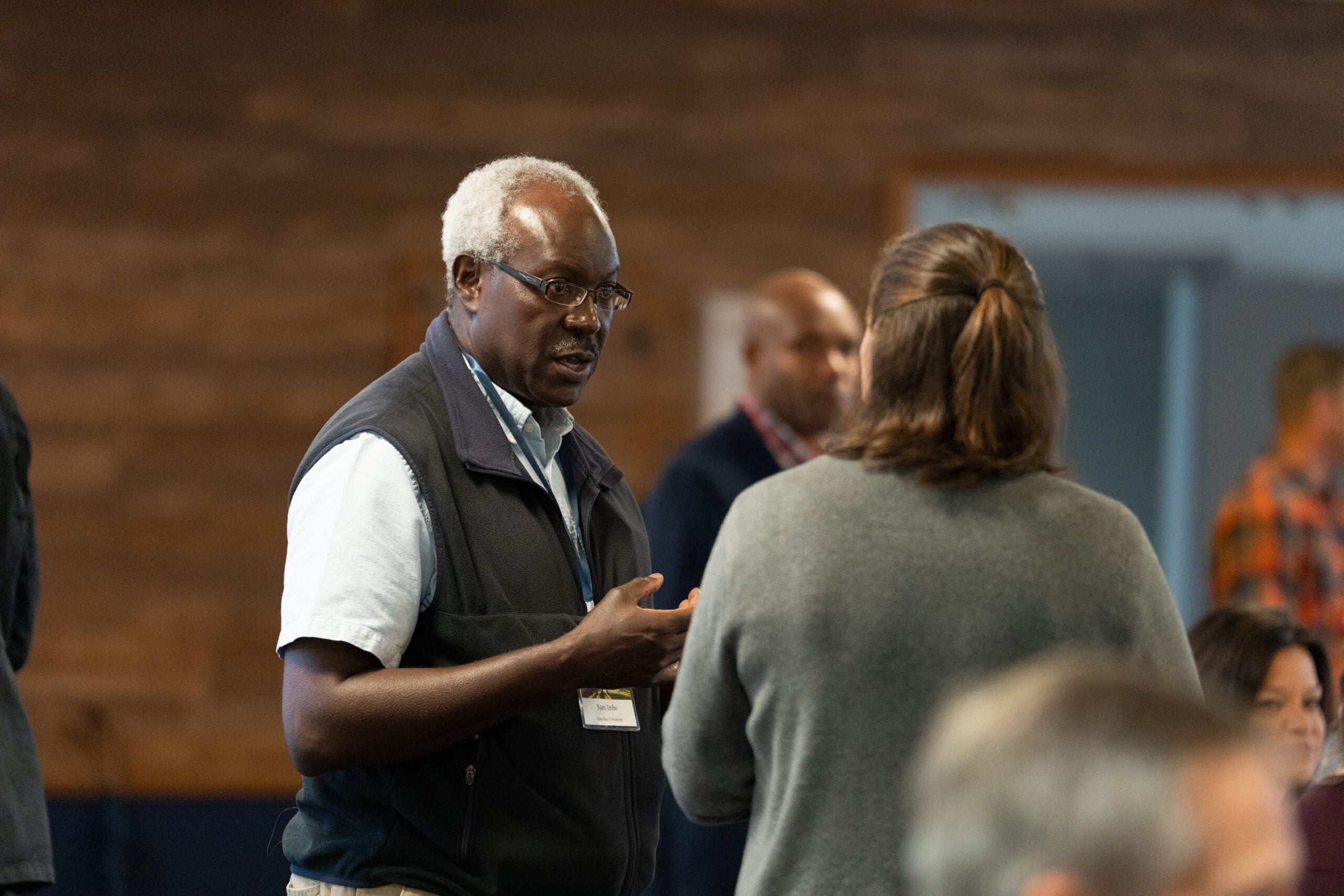 A man and a woman speak at a Regional Gathering.